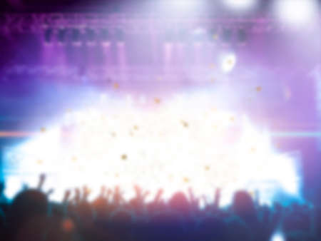 Blurred concert crowd shot, people and a stage are visible.の写真素材