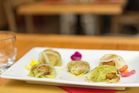 Selective focus on steamed stuffed cabbage in white plate on wooden table