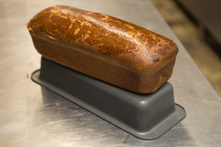 Freshly baked homemade loaf of bread on a metal surface.