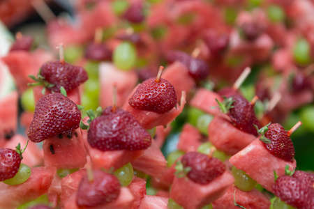 Close-up of fresh fruits on skewers on a buffet tableの写真素材