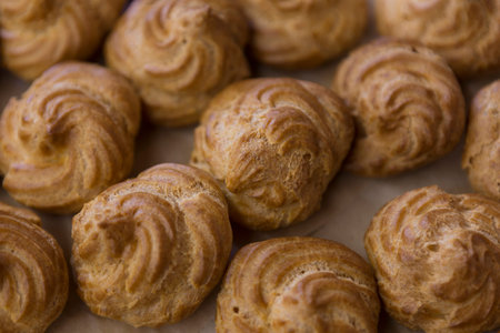 Cream puff cakes on a baking sheet. Selective focus.