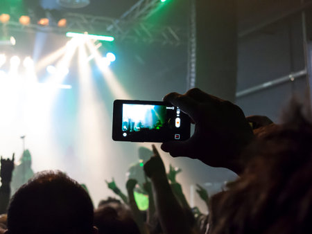 Concert spectators in front of a bright stage with live music