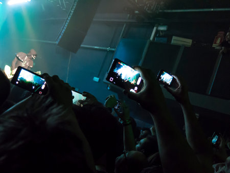 Concert spectators in front of a bright stage with live music