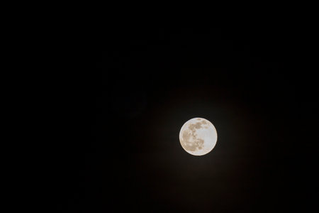 Long telephoto lens shot of the moon in a black sky.の写真素材