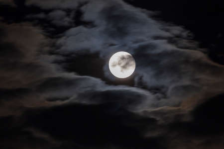 Long telephoto lens shot of the moon in a black sky.の写真素材