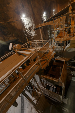Inside a dark quarry mining plant, no people are visible.