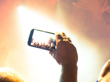 Concert photography. A smartphone in the hands of a man during a concert.の写真素材