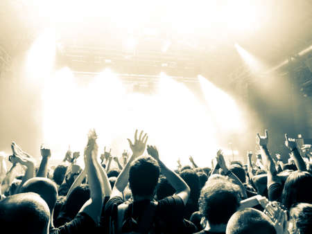 Crowd at a music festival with hands raised up in the airの写真素材