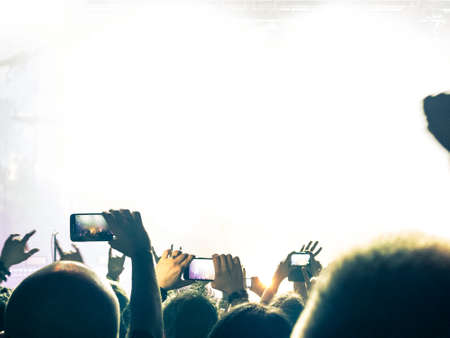 Crowd at a concert taking a picture with a smart phone.の写真素材