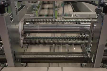 Close up detail of cartographic industrial machinery at work in a production line, conveyor belts...