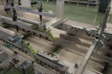 Close up detail of cartographic industrial machinery at work in a production line, conveyor belts...