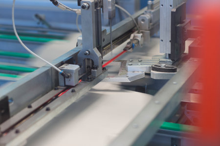 Close up detail of cartographic industrial machinery at work in a production line, conveyor belts are visible, no people are present.の写真素材