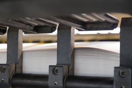 Close-up image of a printing machine with sheets of paper.