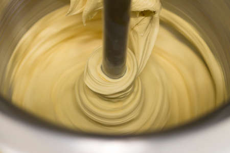A closeup shot of a mixer mixing dough in a metal bowlの写真素材