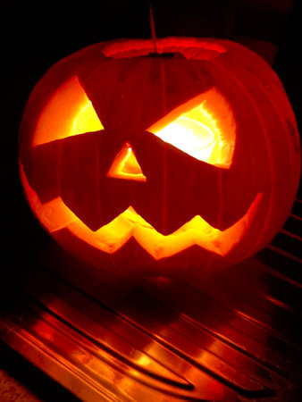 Halloween pumpkin head jack lantern glowing in the dark, close upの写真素材