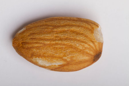 Close up on almonds resting on a flat background.