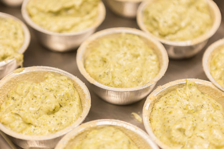 Close up of mini tartlets filled with pesto sauce ready to be servedの写真素材