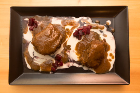 Meatballs with yoghurt and cranberries on a plateの写真素材