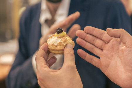 Close-up of a man holding a muffin in his handの写真素材