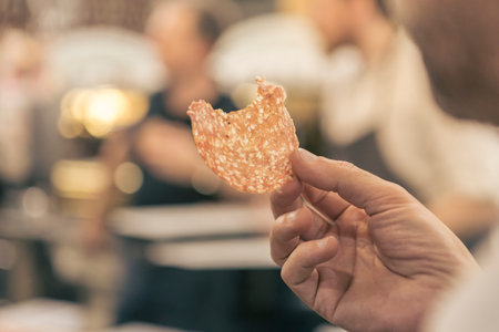 Close up of a hand holding a potato chip.