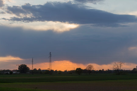 Sunset in the countryside with a cloudy sky over the field.の写真素材
