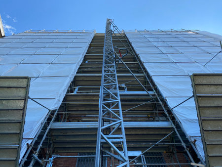 Stainless steel scaffolding on a building under construction with blue skyの写真素材