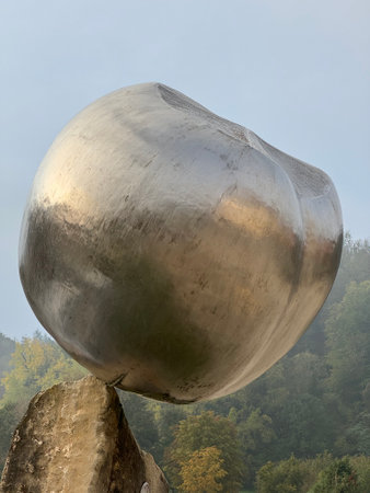 sculpture in the form of a ball on a rockの写真素材