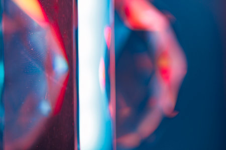 Overlay of a light leak coloured in red and cyan hues. Background is dark.の写真素材