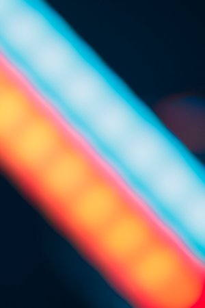 Overlay of a light leak coloured in red and cyan hues. Background is dark.の写真素材