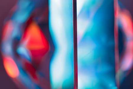 Overlay of a light leak coloured in red and cyan hues. Background is dark.の写真素材