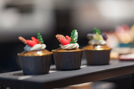 Cupcakes with cream and berries on a table in a restaurant