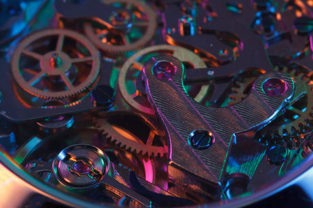 Close up detail of a macro clockwork inside a shiny iron wristwatch with sapphire rear glass bottom.