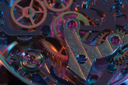 Close up detail of a macro clockwork inside a shiny iron wristwatch with sapphire rear glass bottom.