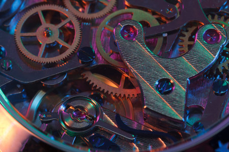 Close up detail of a macro clockwork inside a shiny iron wristwatch with sapphire rear glass bottom.