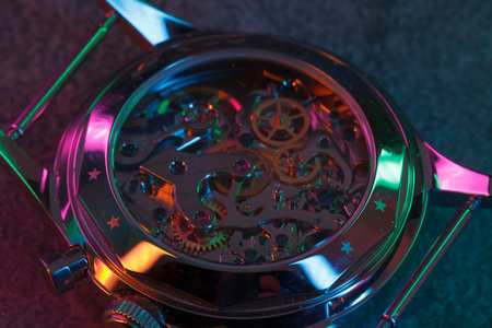 Close up detail of a macro clockwork inside a shiny iron wristwatch with sapphire rear glass bottom.の写真素材