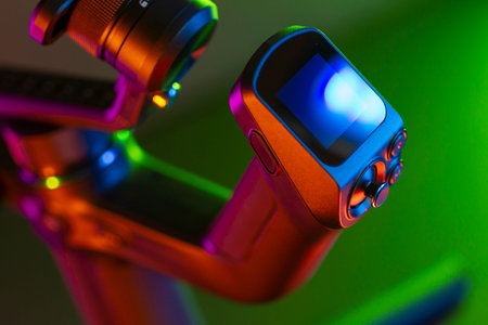 Close up on a modern gimbal for videomaking, background is black.