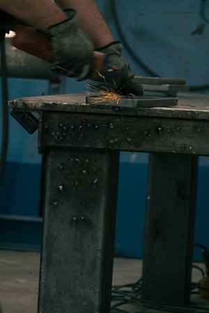 Detail of heavy industry manufacturing, sparks come out of a metal working welder.