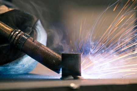 Detail of heavy industry manufacturing, sparks come out of a metal working welder.の写真素材