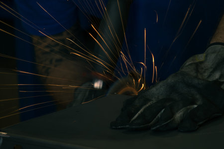 Detail of heavy industry manufacturing, sparks come out of a metal working welder.