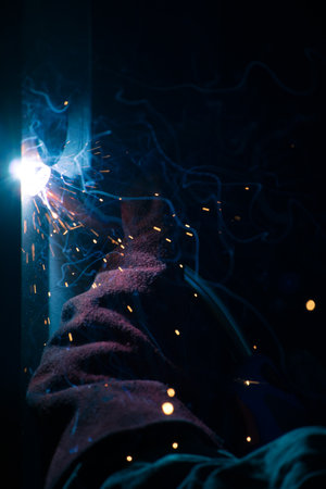 Detail of heavy industry manufacturing, sparks come out of a metal working welder.の写真素材