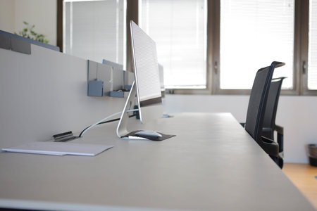 Office table with computer and documents on it. Blurred background.の写真素材