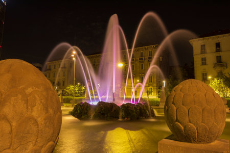 Milan, Italy - August 16, 2024: night street view of Piazza Giulio Cesare with the fountain of the Four Seasons (Fontana quattro stagioni).の写真素材