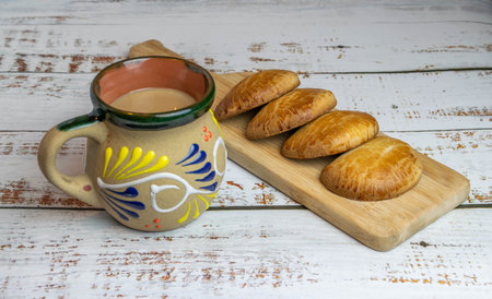 Mexican coffee in Mexican decorated cup on white wooden table with Hand Pies