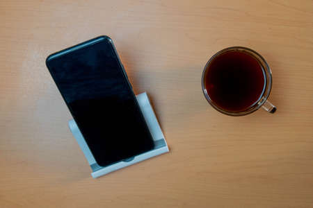 Office composition with smartphone and coffee on wooden deskの写真素材