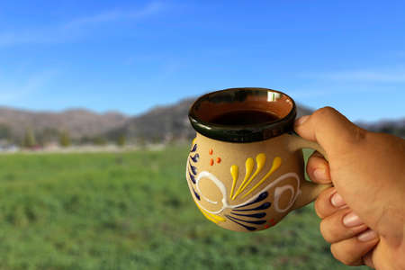 Pov photo of Mexican cup of coffee with mountains in the backgroundの写真素材