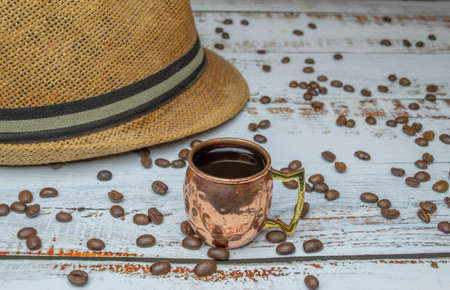 copper cup with espresso on white wooden table with organic coffee beans with Cuban hat in the backgroundの写真素材