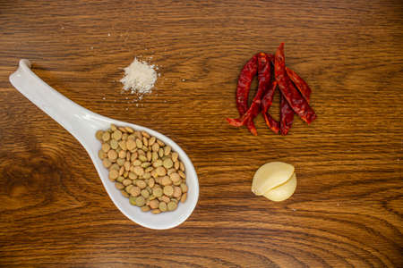 Ingredients for spicy lentils on the table are , lentils, red chili and saltの写真素材