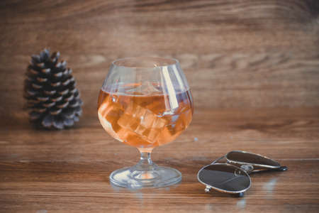 Business composition with glass with delicious whiskey next to aviator lenses. on oak boardsの写真素材