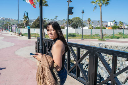 beautiful mexican girl walking on the pier in front of the sea