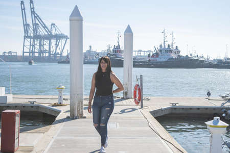 beautiful mexican girl walking on the pier in front of the seaの写真素材